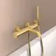 Badearmatur in Brushed Gold mit Handbrause und Wandhalter. Ideal Standard Produkt. Befestigungselemente sind sichtbar an der Wand montiert.